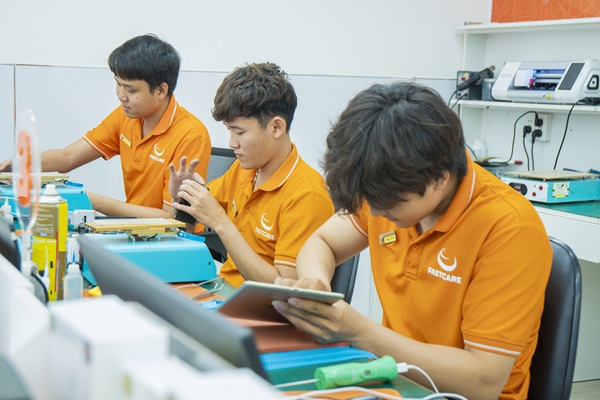 kỹ thuật viên FASTCARE đang sửa chữa điện thoại cho khách