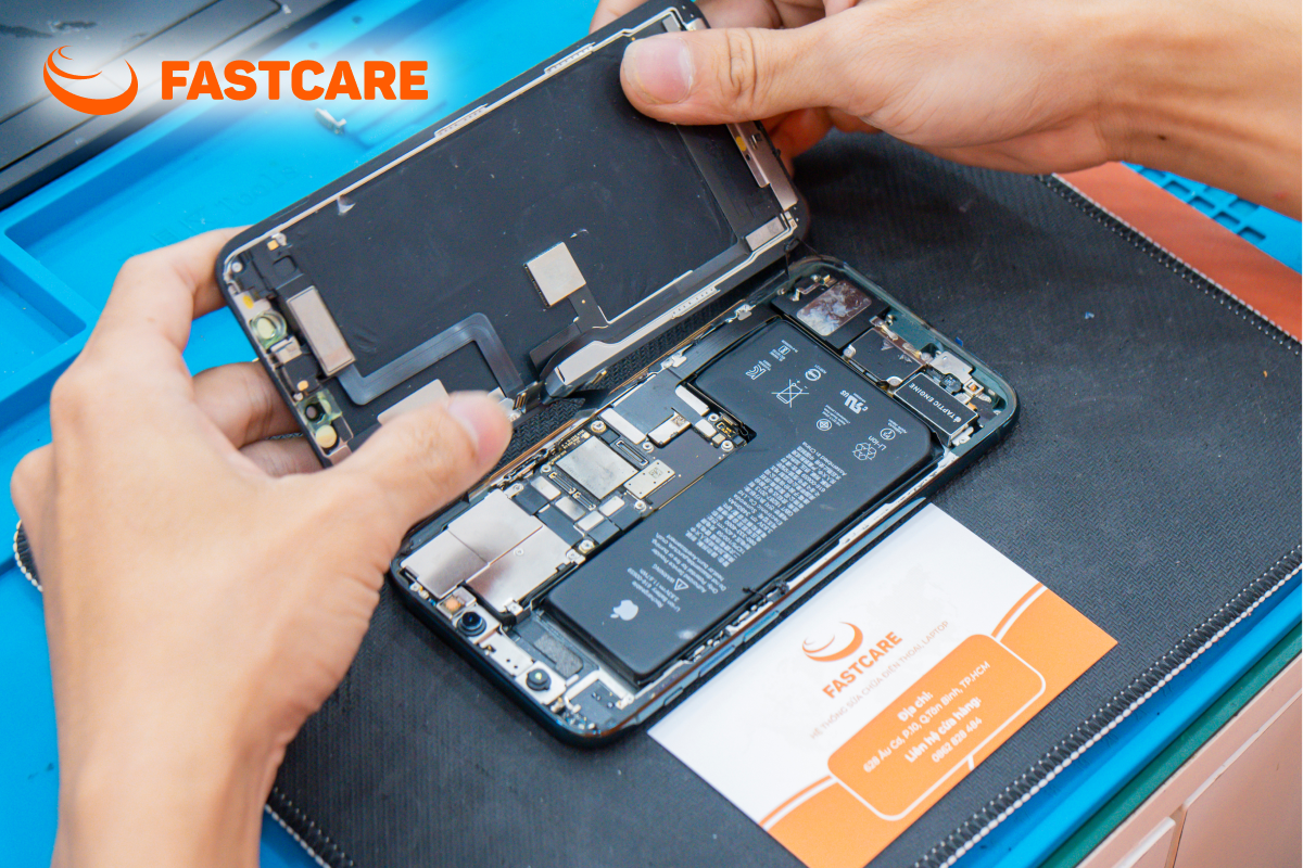 Kỹ thuật viên mặc áo FASTCARE thao tác cẩn thận tại bàn sửa chữa